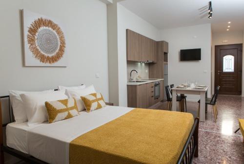a bedroom with a large bed and a kitchen at Fyllianos Apartments in Plátanos