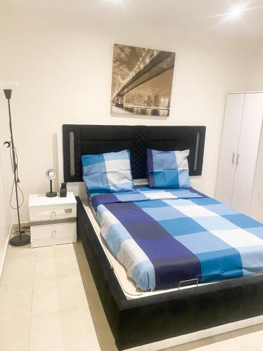 une chambre avec un grand lit avec des draps bleus et blancs dans l'établissement Logement à 20 mins de paris , Stade 2 France, Aéro CDG, Parc des expositions, à Arnouville-lès-Gonesse