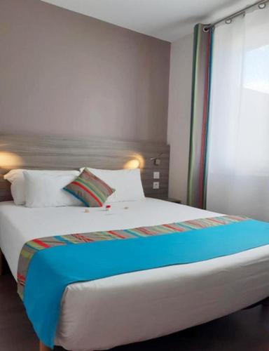 a bedroom with a large bed with a window at Hotel Le Majestic Canet plage in Canet-en-Roussillon