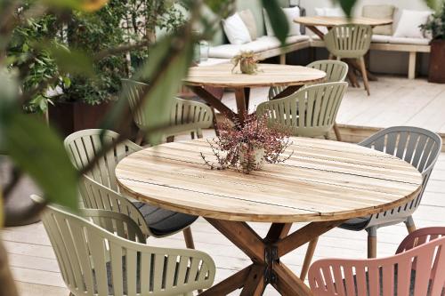 a wooden table and chairs in a patio at Lieperts Cafe Dinner Rooms Boutiqe-Zimmer Südsteiermark in Leutschach