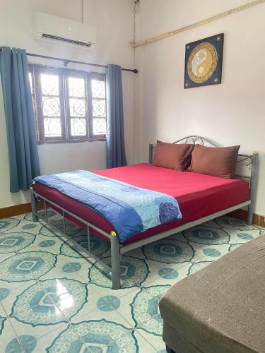 a bedroom with a bed with a red and blue comforter at Mabuhay Guest House, Thai Embassy Vientiane in Vientiane