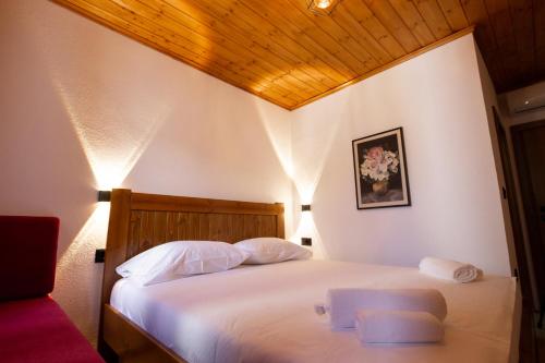 a bedroom with a bed with two white pillows at Old Street Villa in Gjirokastër