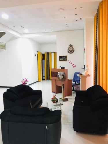 a living room with two black chairs and a podium at Ops Poinix Hotel in Weerawila