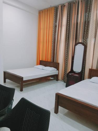 a room with two beds and a mirror on the wall at Ops Poinix Hotel in Weerawila