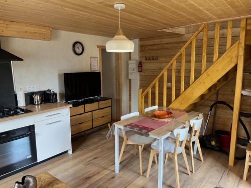 une cuisine et une salle à manger avec une table et des chaises dans l'établissement Maison Boutxy Le Clos des Ours, à Matemale