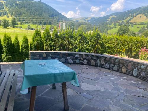 a blue table sitting on a stone patio with mountains in the background at Haus Gantschnigg in Jochberg