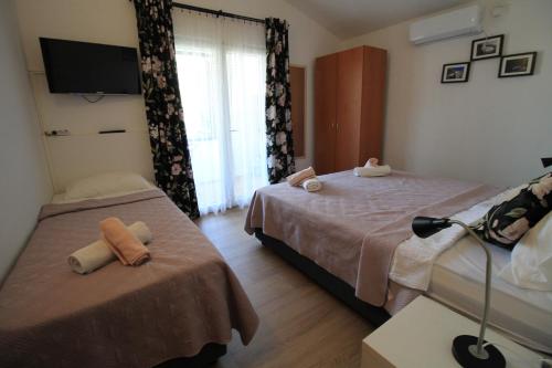 a hotel room with two beds and a tv at Villa Hortus in Neum