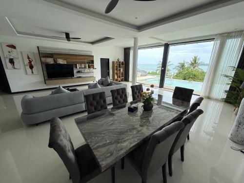 a living room with a table and chairs and a couch at Sunset Paradise Villa in Haad Pleayleam