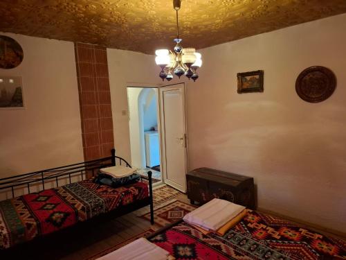 a bedroom with a bed and a chandelier at Retro Retreat Izačić in Bihać