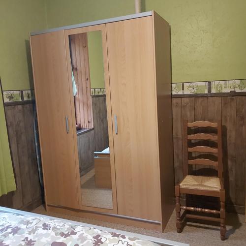 - une grande armoire en bois avec un miroir dans la chambre dans l'établissement appartement chez Chantal RDC 60m2 GERARDMER, à Gérardmer