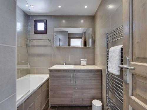 une salle de bain avec une baignoire et un lavabo et une baignoire dans l'établissement Charmant Appartement à Tignes Val Claret, Près des Commerces et Pistes, WiFi et Balcon Inclus - FR-1-641-26, à Tignes