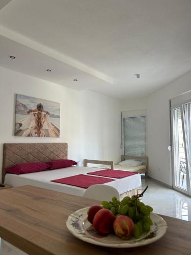 a bedroom with a bed and a plate of fruit on a table at Apart Hotel White Pearl in Bar