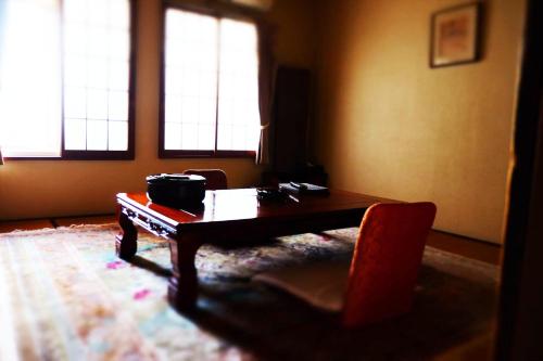 a living room with a table and a chair at Hotel Sumire ふぐ料理を愉しむ料理宿 in Shimonoseki