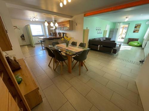 a dining room and living room with a table and chairs at Ferienhaus Haus Auenland in Nohfelden