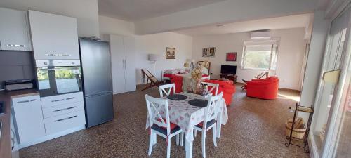 une cuisine et un salon avec une table et des chaises dans l'établissement Apartman Ivan, à Mandre
