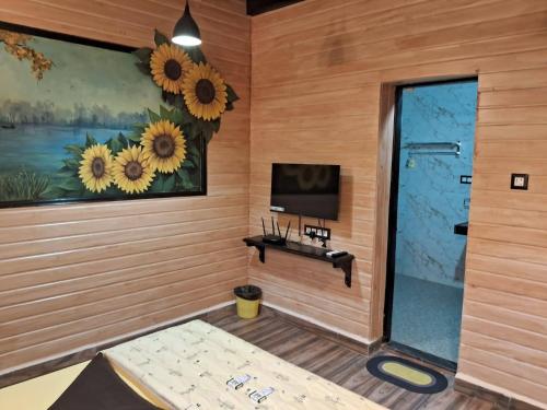 una habitación con TV y una pared con girasoles en Mudra beach villa Gokarna, en Gokarna