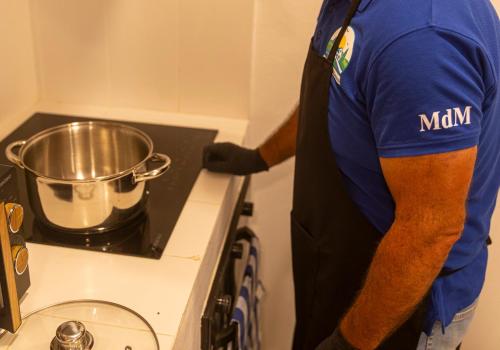 a man in an apron cooking on a stove at MdM - Monte dos Mestres in São Domingos