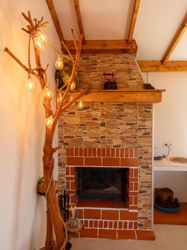 a brick fireplace with a christmas tree and lights at MdM - Monte dos Mestres in São Domingos