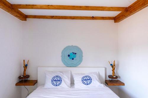 a bedroom with a white bed with white pillows at MdM - Monte dos Mestres in São Domingos