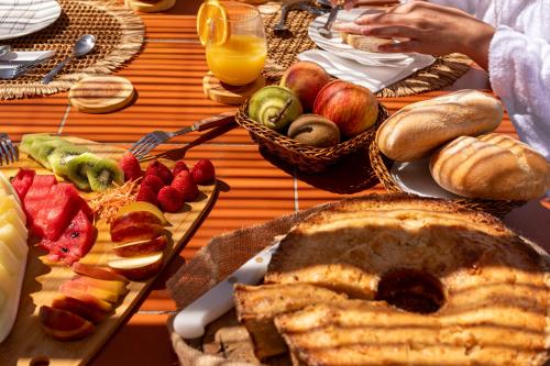a table with a plate of bread and fruit on it at MdM - Monte dos Mestres in São Domingos
