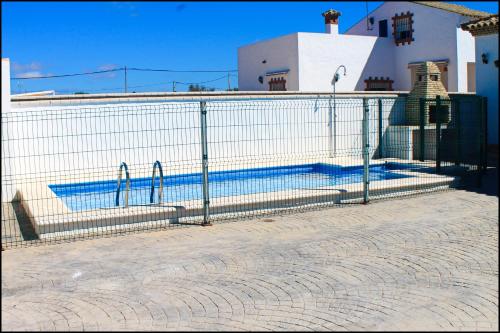 une clôture en face d'une piscine dans l'établissement Chalet Pinar de Roche 118, à Conil de la Frontera