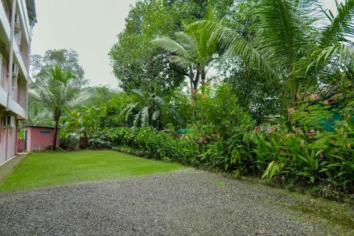 a garden with a lawn and trees and a building at EN Jays Residency (Service Apartments) in Kottayam