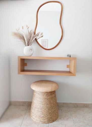 a stool and a mirror on a wall at Lithos in Palaiochóra