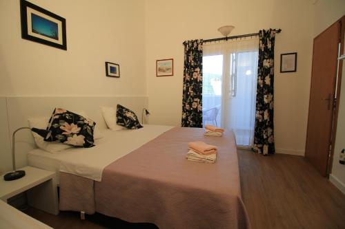 a bedroom with a bed and a window at Villa Hortus in Neum