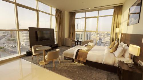 a hotel room with a large bed and a television at Seiba Hotel Apartments-Riyadh in Riyadh