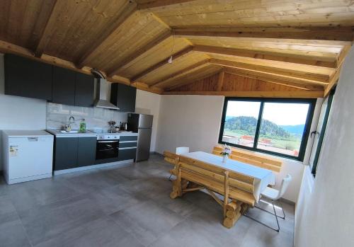a kitchen with a wooden table and a large window at Room 'Šima' with private bathroom and free air-conditioned summer kitchen in Šarića Struga