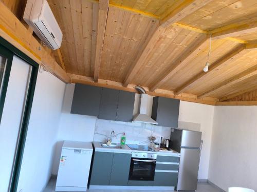a kitchen with a refrigerator and a sink in a room at Room 'Šima' with private bathroom and free air-conditioned summer kitchen in Šarića Struga