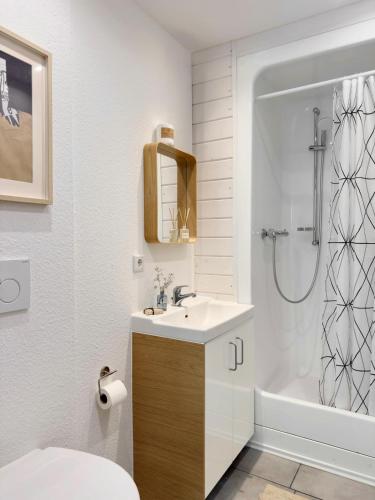 a white bathroom with a sink and a shower at Alte Dorfschmiede - idyllische Ferienwohnung in Meschede-Calle in Meschede
