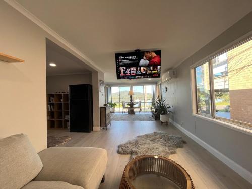 a living room with a couch and a flat screen tv at Riverside Retreat in Karuah