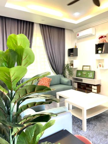 a living room with a couch and a plant at Amdel Home in Kampung Raja