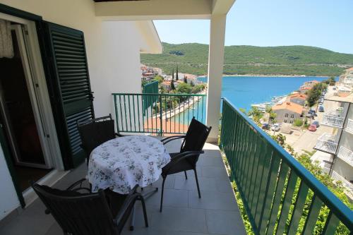 a balcony with a table and chairs and a view of the water at Villa Hortus in Neum