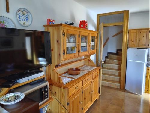 a kitchen with wooden cabinets and a staircase at Il tabià di Ugo e Maria in Laggio