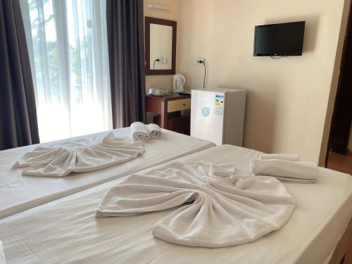 a bed with two white blankets on top of it at LEMAS SUITE HOTEL in Side