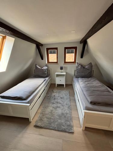 two beds in a room with windows and a rug at Ferienhaus Lubentiusblick Limburg in Limburg an der Lahn
