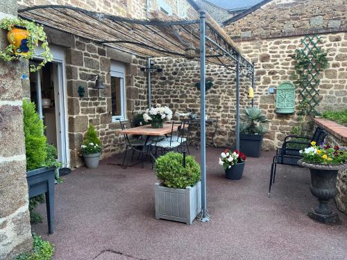 a patio with a table and chairs and plants at LA VIE DE CHATEAU EN TOUTE AMITIE ET SIMPLICITE in Montaudin