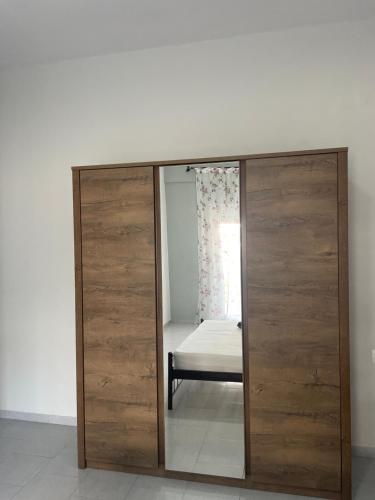 a wooden wardrobe with a mirror in a room at Nemesis in Litochoro