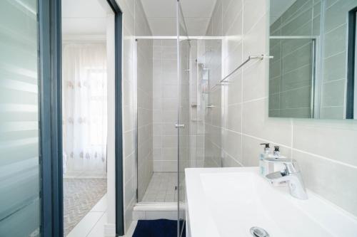 a white bathroom with a shower and a sink at Ballito Hills 327 in Ballito