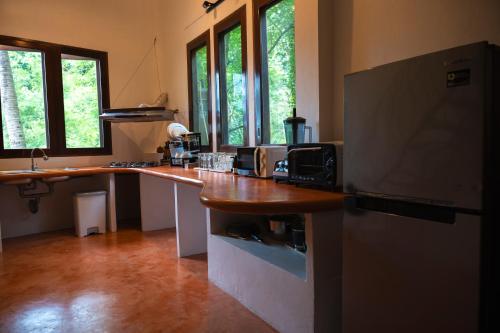 a kitchen with a refrigerator and a counter top at Monkey Flower Villas in Koh Tao