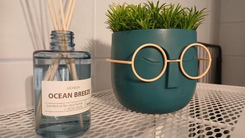 a vase with glasses next to a bottle of water at Roland's home in Alexandroupoli
