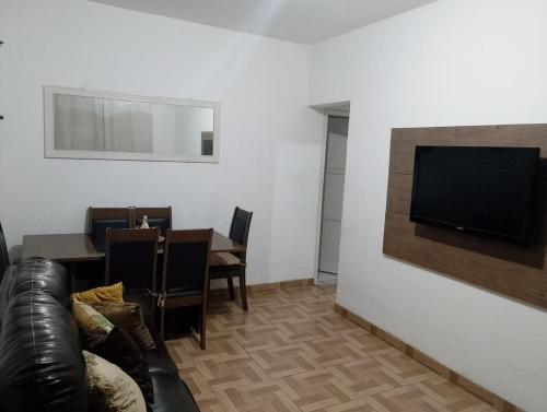 a living room with a couch and a television on a wall at Carlos in Salvador
