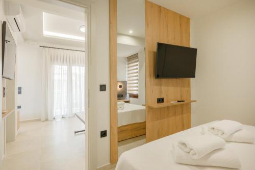 a bedroom with a television and a bed with towels at Anesis Apartments in Ierissos
