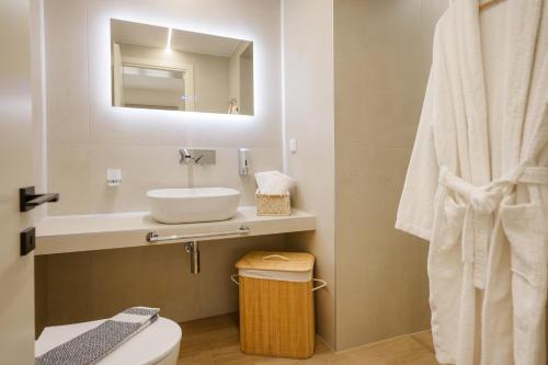 a bathroom with a sink and a toilet and a mirror at Anesis Apartments in Ierissos