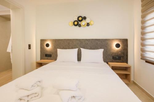 a bedroom with a large bed with white sheets at Anesis Apartments in Ierissos