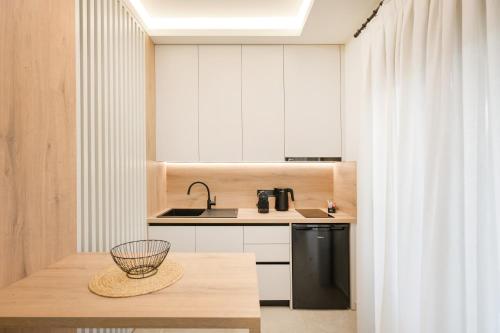 a kitchen with a table and a black refrigerator at Anesis Apartments in Ierissos
