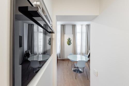 a living room with two tables and chairs in a room at Fully furnished and modern flat - Brussels center in Brussels