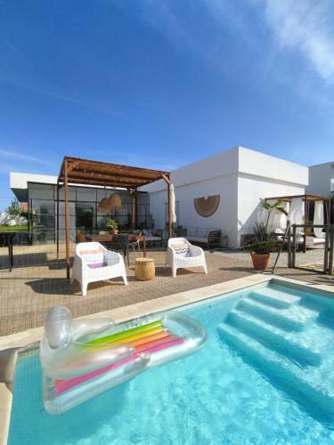 a swimming pool with a inflatable raft in the water at Sunset River Villa, Lisbon in Alcochete